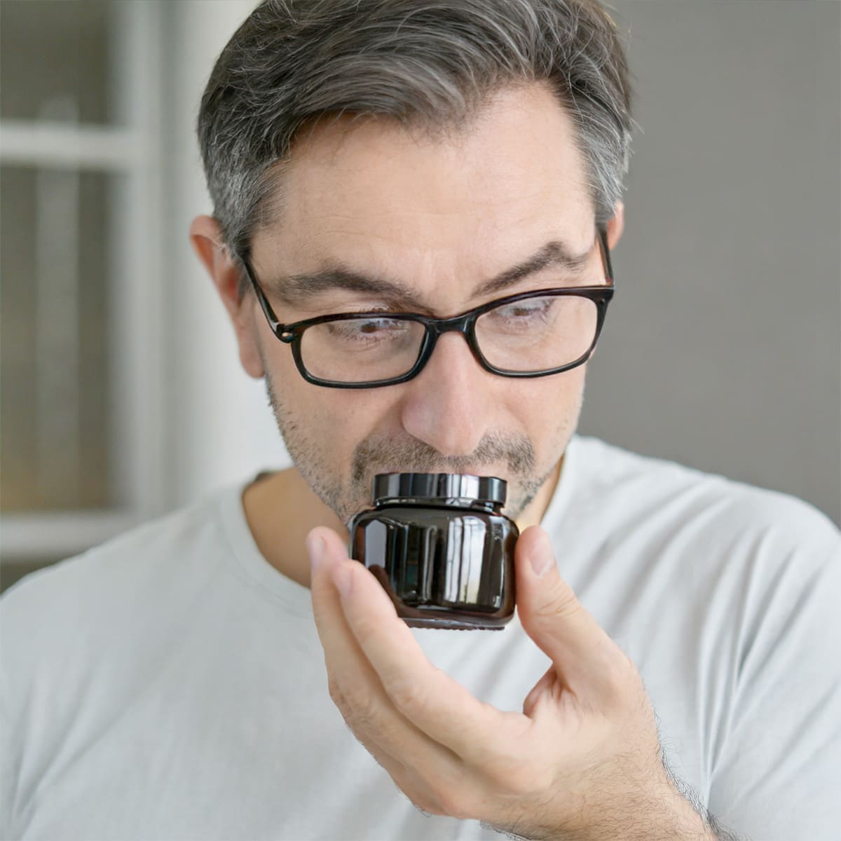 Mann, der an einem Riechglas riecht